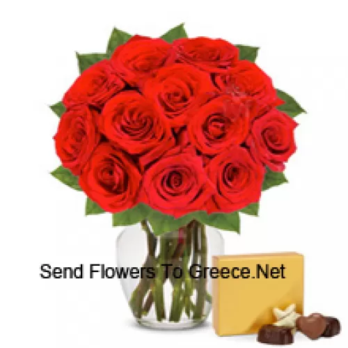 11 ורדים אדומים עם כמה עלים בכוס זכוכית, מלווים בקופסת שוקולד מיובא