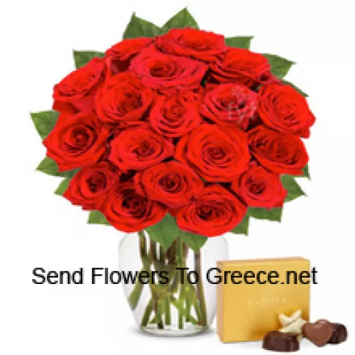 25 czerwonych róż z paprotkami w szklanym wazonie, w towarzystwie importowanego pudełka czekoladek