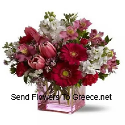 Trandafiri roșii, lalele roșii și flori asortate cu umpluturi sezoniere aranjate frumos într-o vază de sticlă