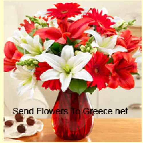 Czerwone gerbery, białe lilie, czerwone lilie i inne różnorodne kwiaty pięknie ułożone w szklanej wazie