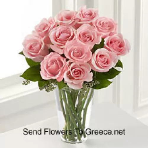 一束装有11朵粉玫瑰和一些蕨类植物的花瓶