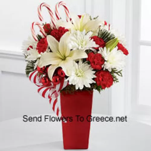 Bursts with the bright cheer and jubilant beauty of this special season. White Asiatic Lilies and chrysanthemums sit amongst red mini carnations, assorted holiday greens, red glass balls, three candy canes and festive ribbon, perfectly arranged in a red ceramic vase to create a lively bouquet of merry wishes for a splendid holiday season! (Please Note That We Reserve The Right To Substitute Any Product With A Suitable Product Of Equal Value In Case Of Non-Availability Of A Certain Product)