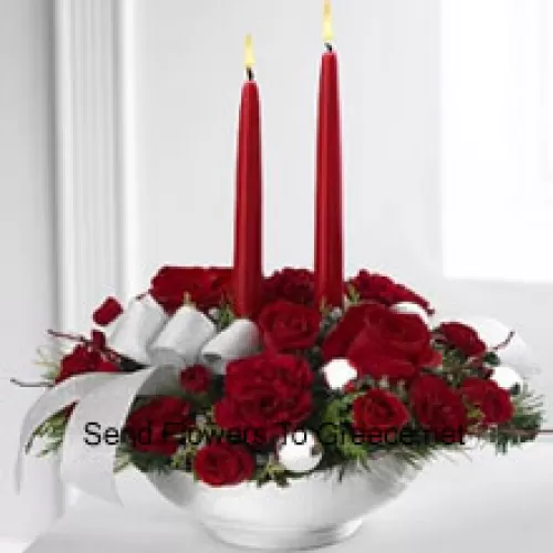 Unser Holiday Elegance Centerpiece wird mit seinem lebendigen Sortiment an roten Blüten einen besonderen Glanz in ihre saisonale Feier bringen! Rote Rosen, Nelken und Sprayrosen sitzen zwischen festlichen Grünpflanzen in einem edlen silbernen Keramikbehälter, verziert mit einem wunderschönen silbernen Band und zwei Kerzen, um ihrem Tisch einen festlichen Glanz von Wärme und Frieden zu verleihen. (Bitte beachten Sie, dass wir uns das Recht vorbehalten, jedes Produkt durch ein gleichwertiges Produkt zu ersetzen, falls ein bestimmtes Produkt nicht verfügbar ist)